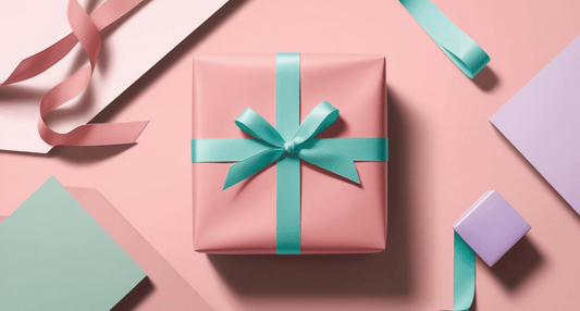 pink gift wrapped with greenish blue ribbon pink background